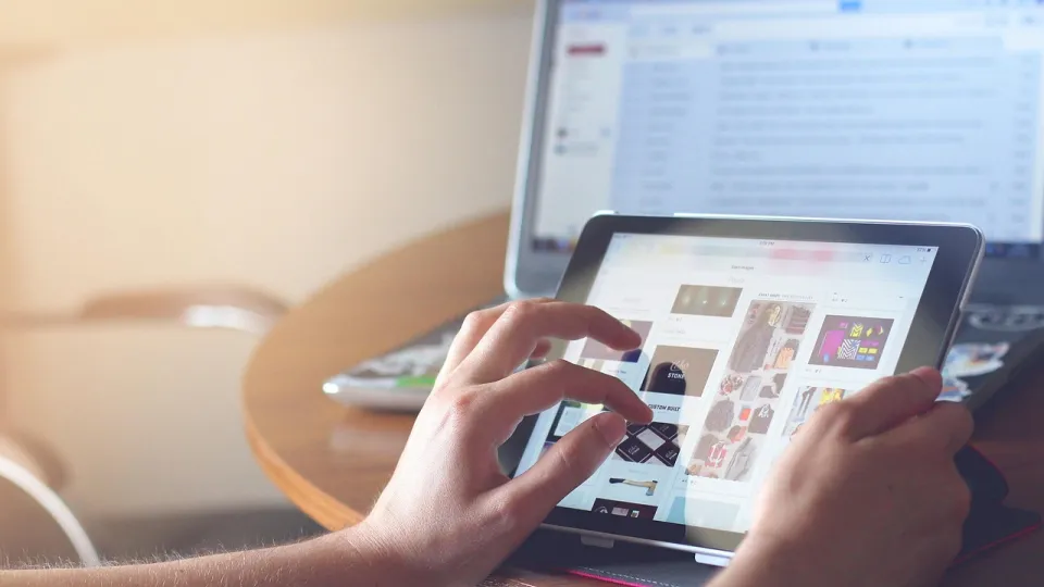 Händer och bildskärmar som illustrerar att någon skrollar på en laptop